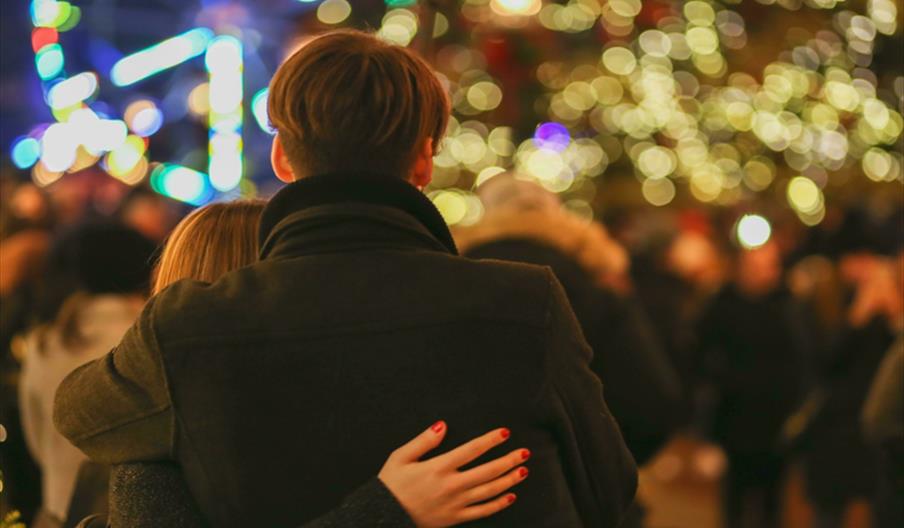 Couple looking out over Christmas outdoor gathering