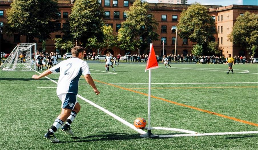 Man playing in a football match doing a corner kick