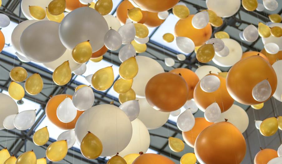 White and gold balloons tied to a string