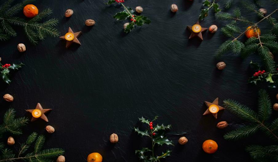 Candles and Christmas decorations on slate background