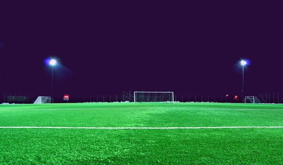 Empty football pitch at night with lights